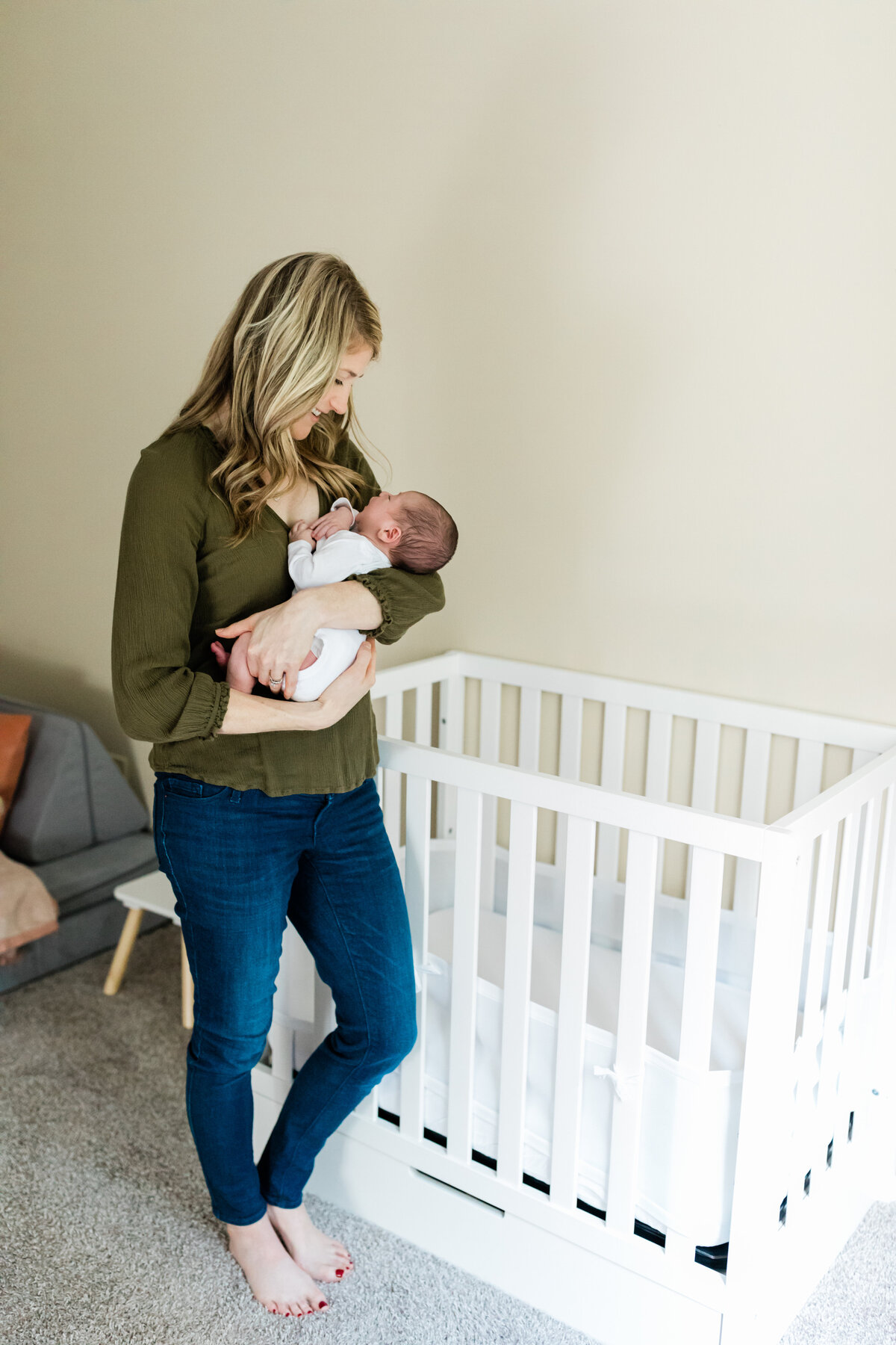 newborn baby boy in white onesie laying in crib cleveland newborn photographer
