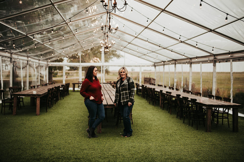 two women standing in a clear tent
