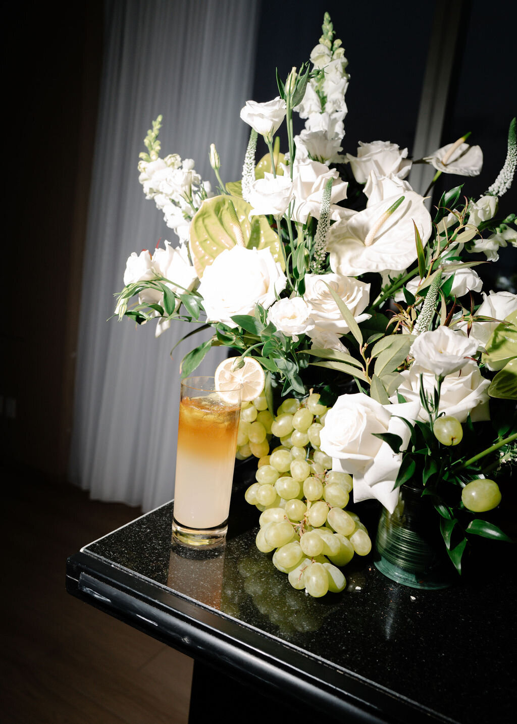 Bar floral arrangement with grapes and a cocktail at Public Hotel NYC