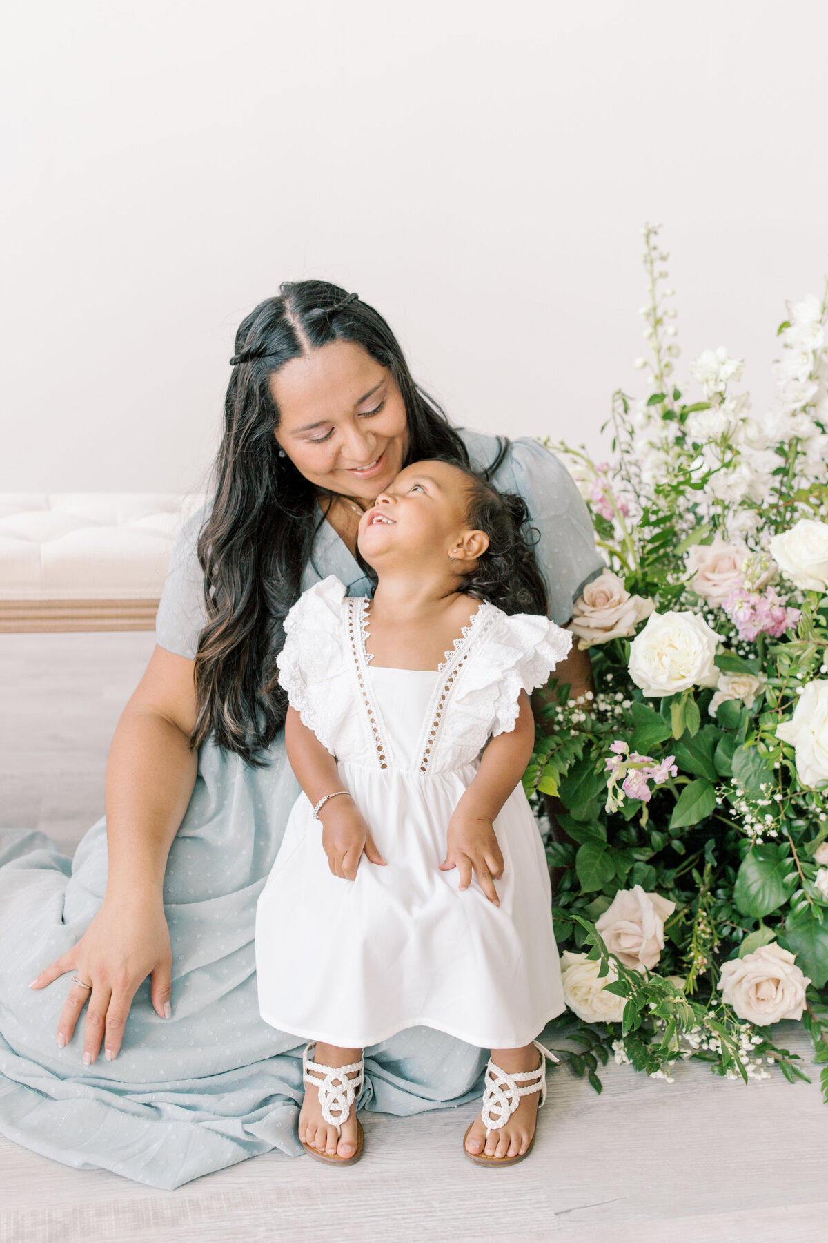 mom and daughter in a photo studio with floral arrangement by one of the photographers in spokane wa