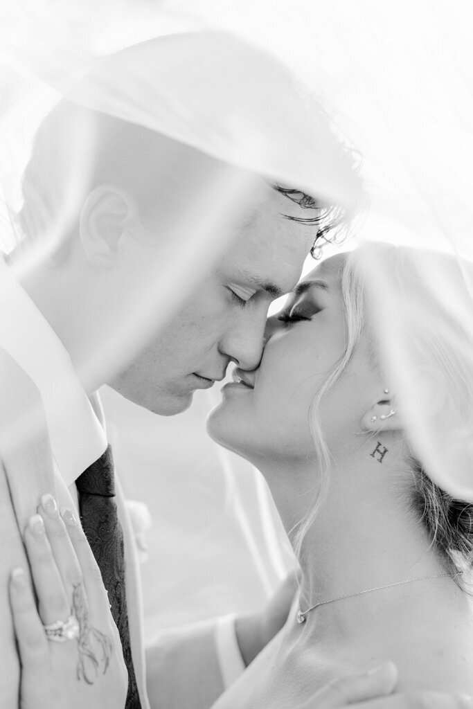 Bride and groom embracing under brides veil, captured by Lorissa Lee Photography. Featured on Brontë Bride.