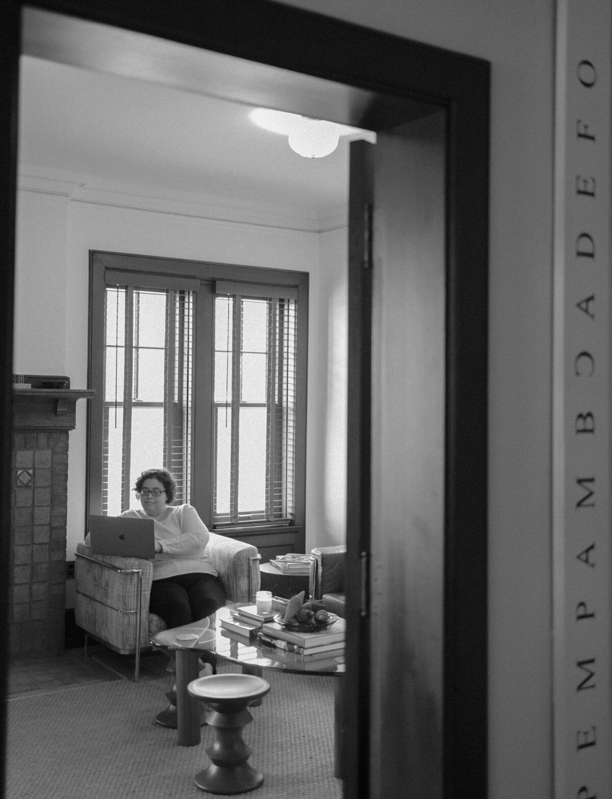 woman on laptop at ALEO Detroit bed & breakfast, web designer branding photoshoot
