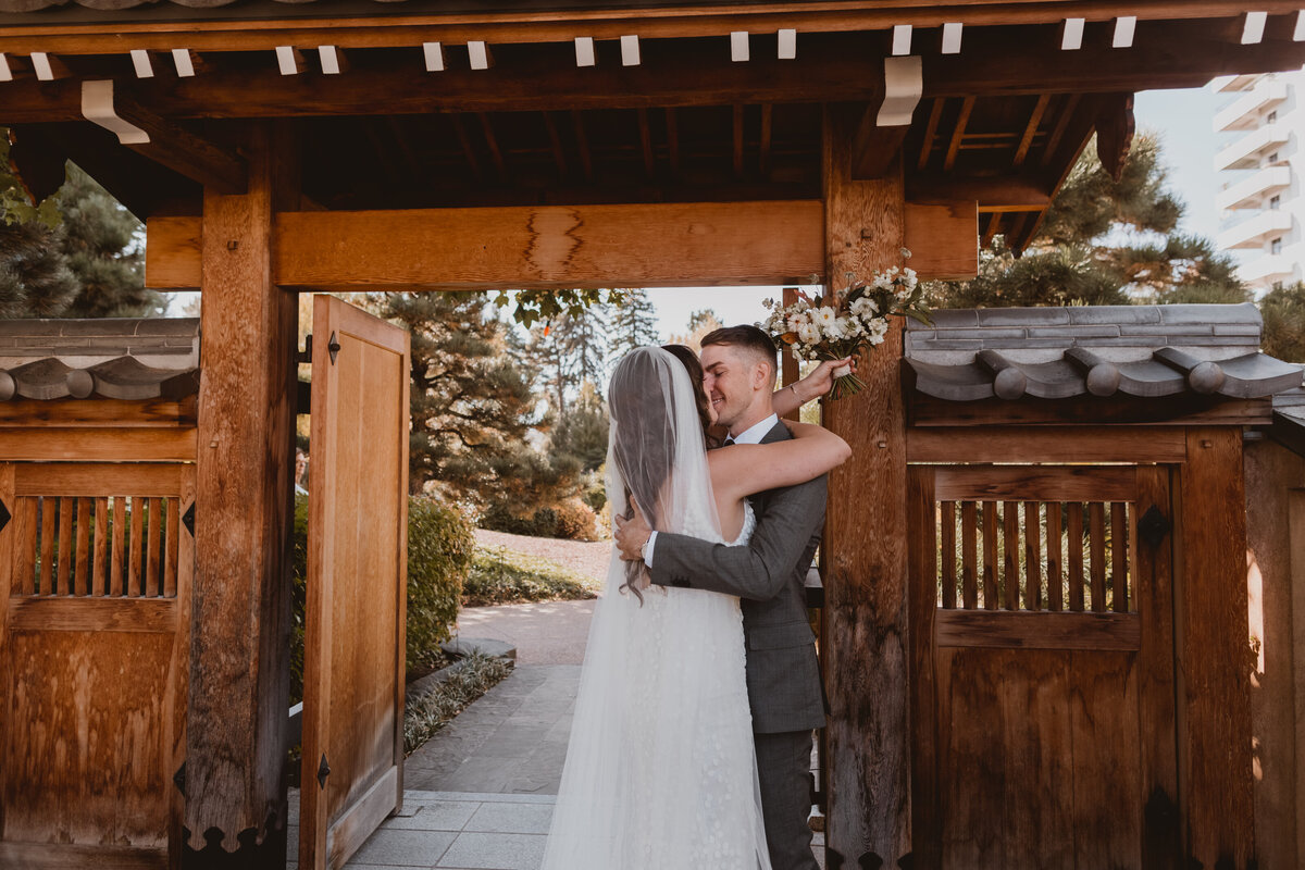 Bride and groom share a kiss at the Denver Botanic Gardens on their wedding day.