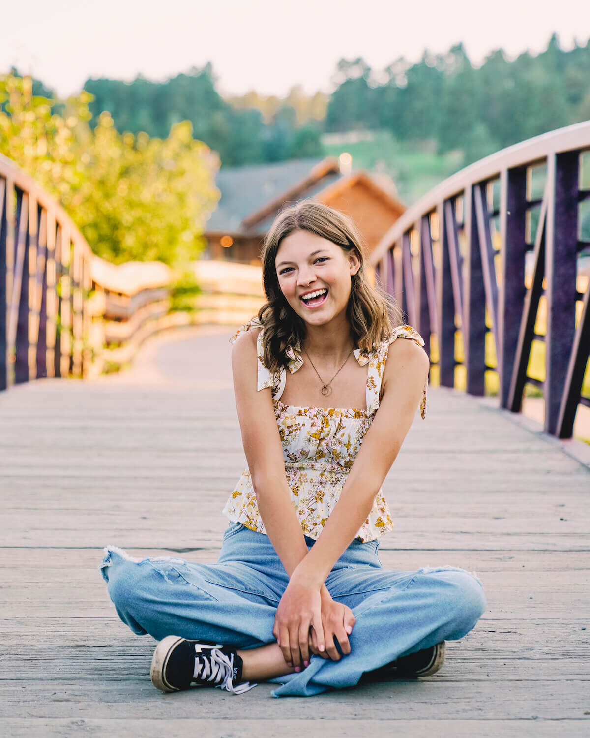 senior photography denver - teen girl sitting on bridge