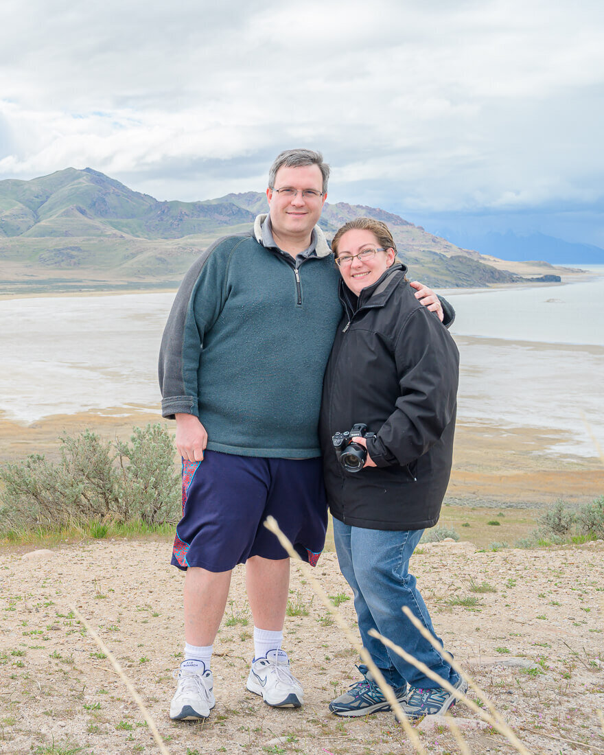 Joseph and Melissa smiling on a windy day at Antelope Island in the early spring