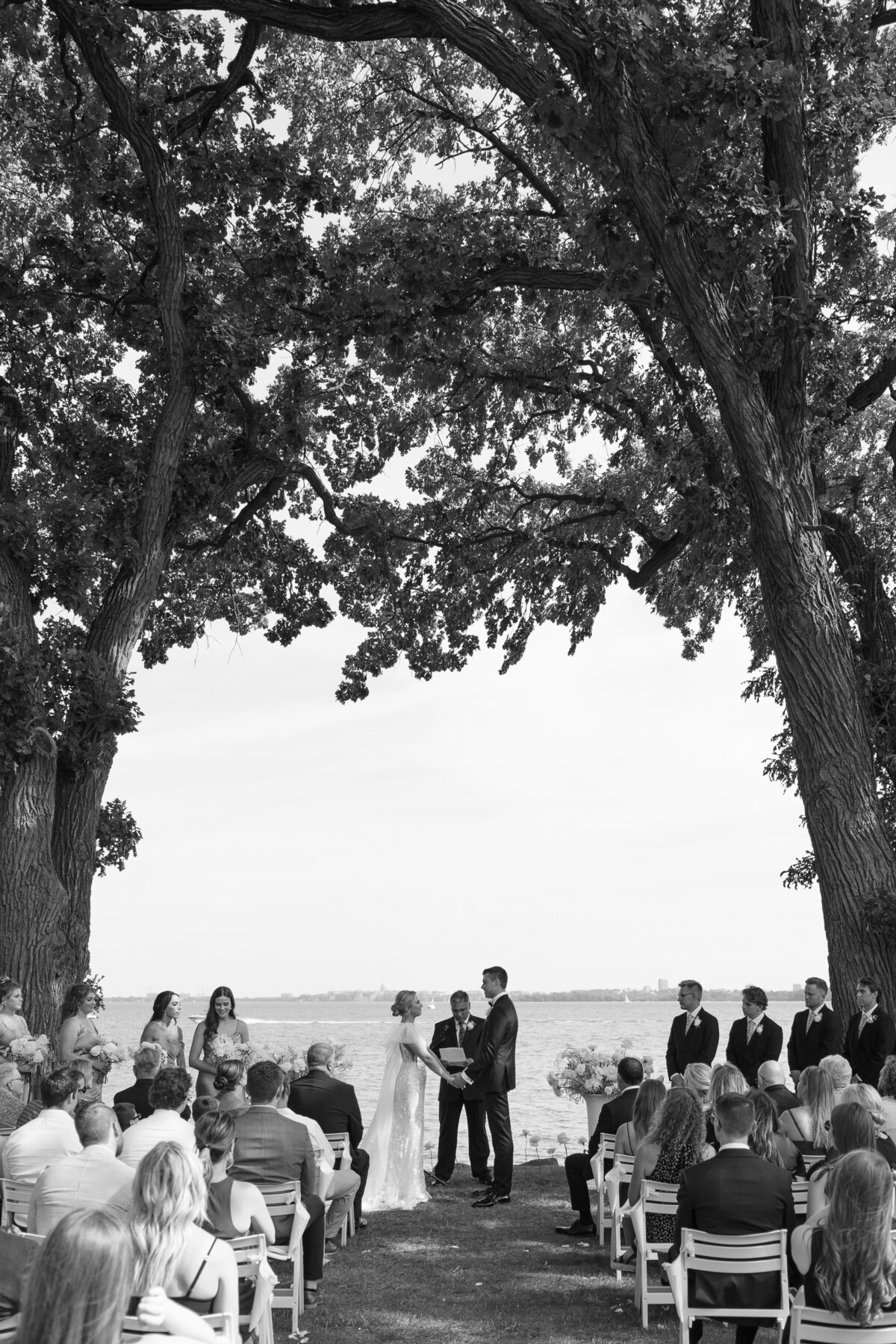 The couple exchanged vows under a sunny blue sky, surrounded by the scenic beauty of Bishops Bay’s outdoor ceremony space.