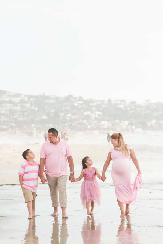 family-in-pink-walking-on-la-jolla-beach-san-diego