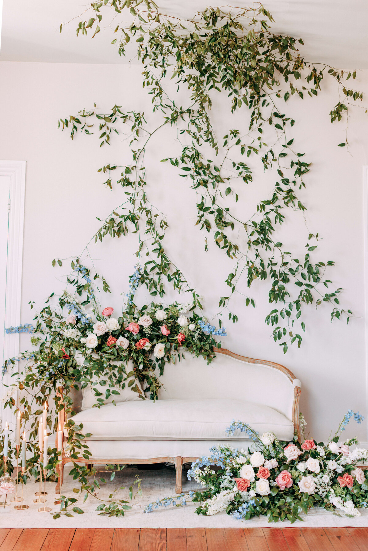 love seat surrounded by greenery and florals
