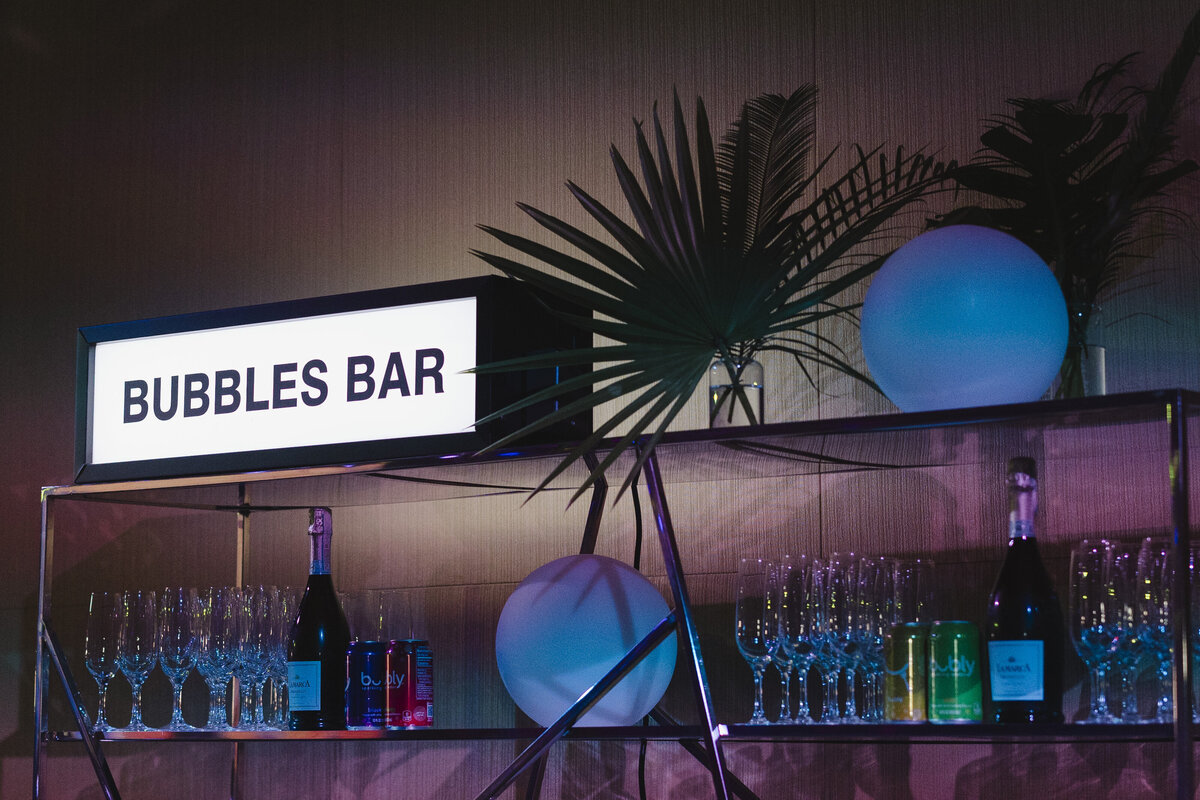 Drinks and glasses stand on a bar table.