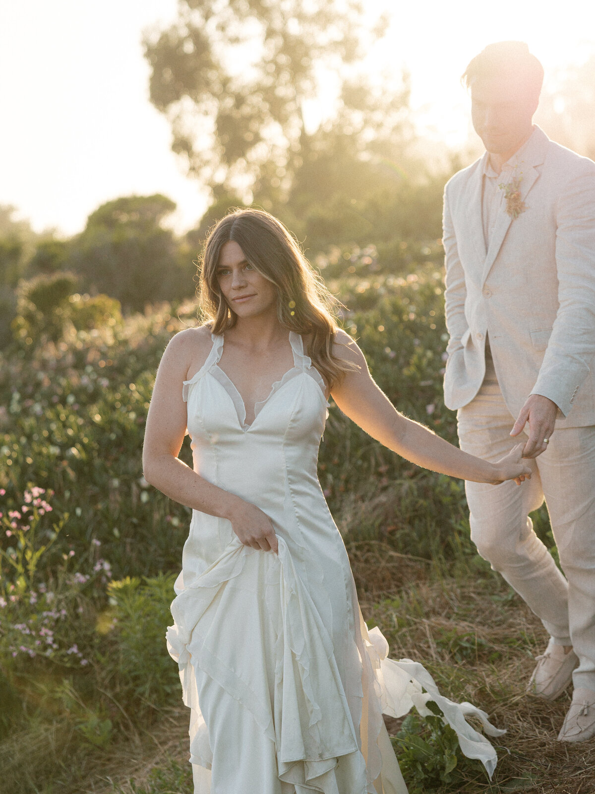 Elegant couple standing hand in hand on a scenic overlook, capturing the breathtaking Southern California landscape in La Jolla.