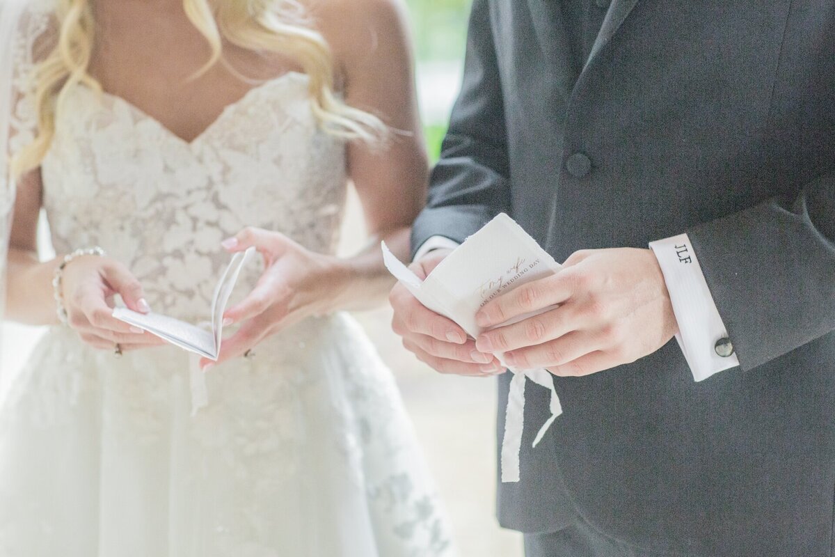 bride and groom reading from vow books at wedding