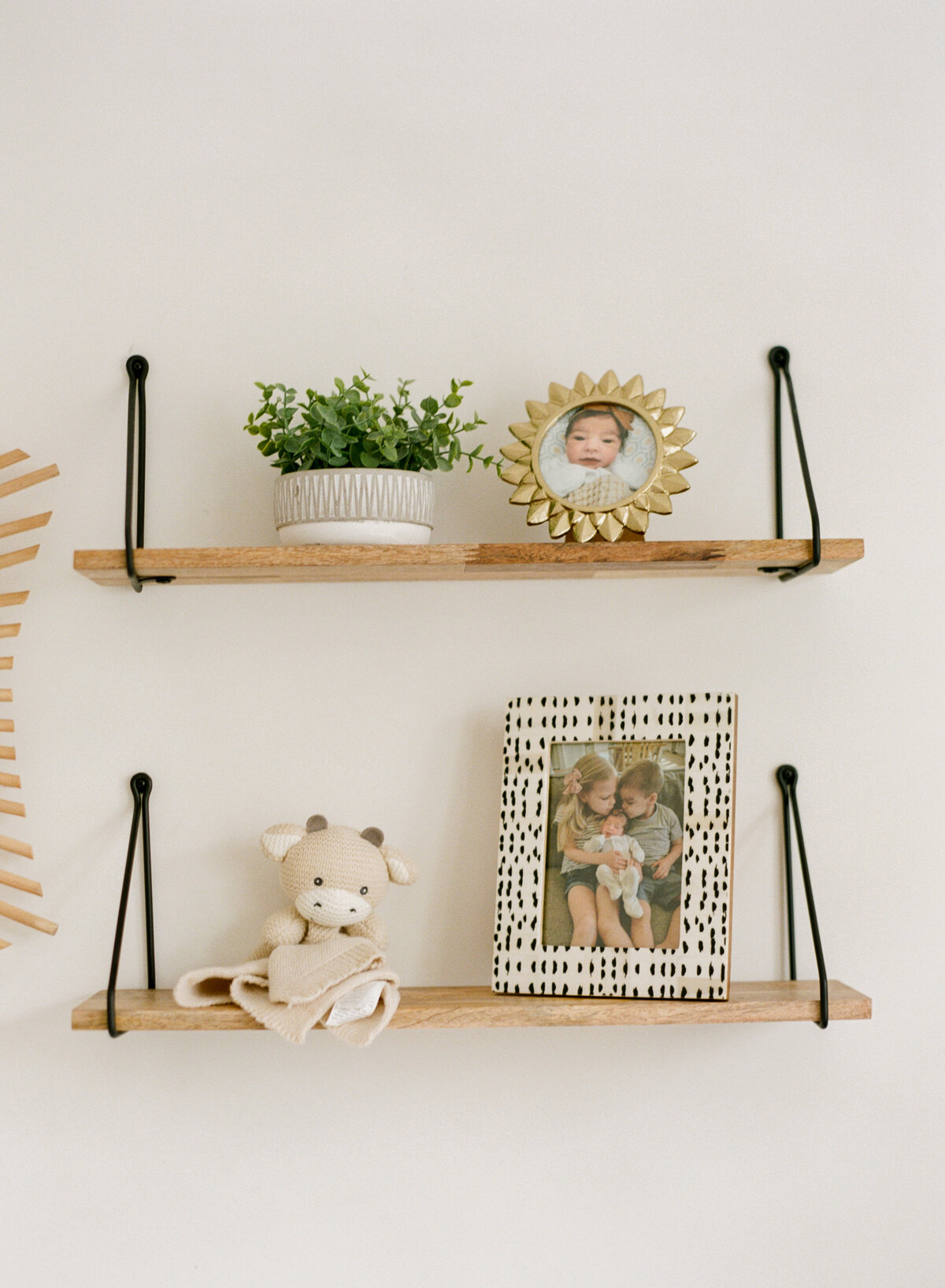 Wood shelves with black hangers are styled beautifully for this organic modern nursery in Raleigh NC. Photographed by newborn photographer Raleigh A.J. Dunlap Photography.