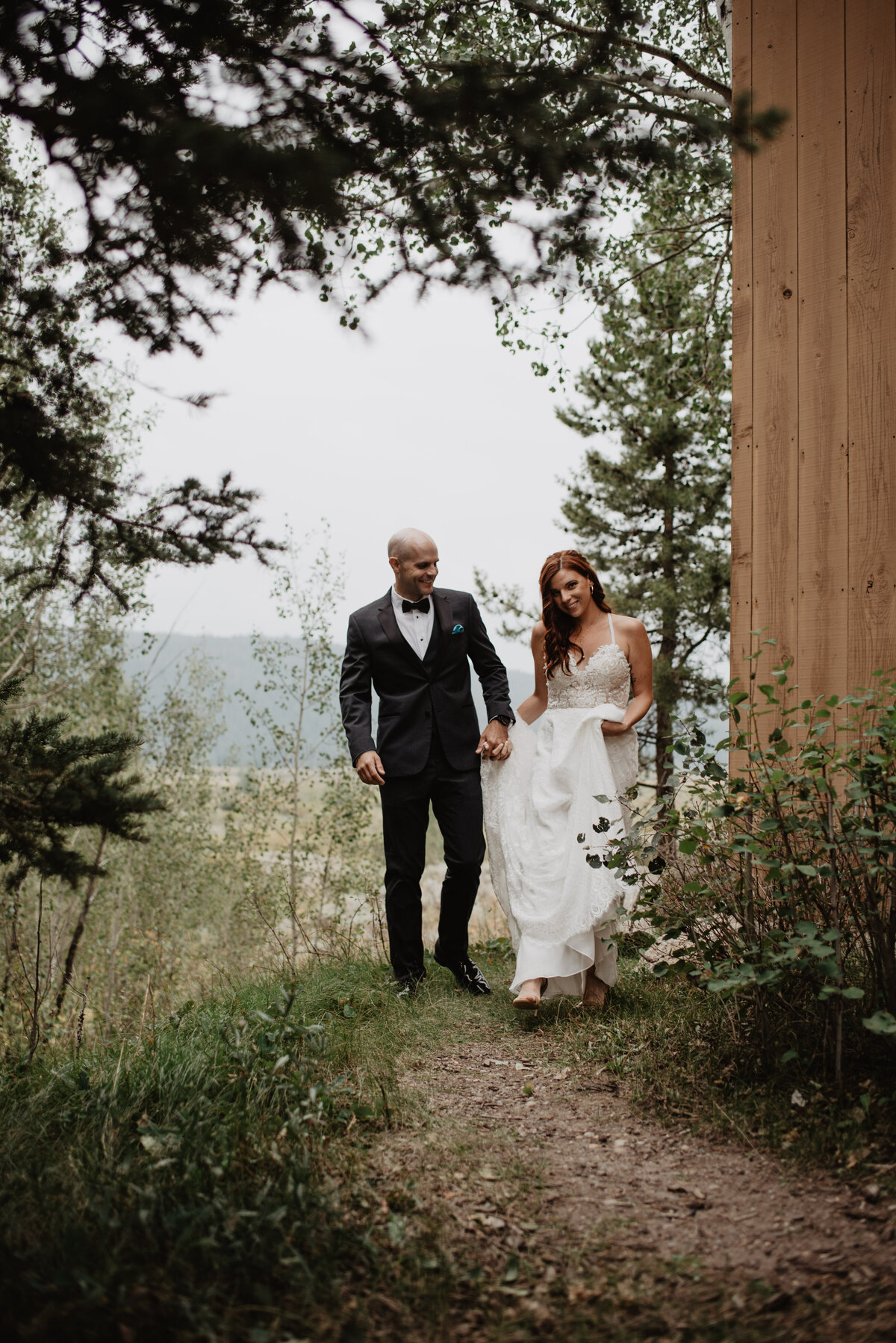 Jackson Hole photographers capture bride and groom holding hands while walking