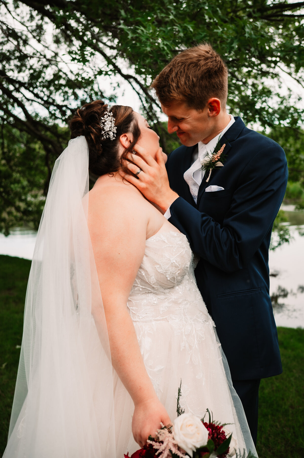 Newlyweds lean in for a kiss in a lawn