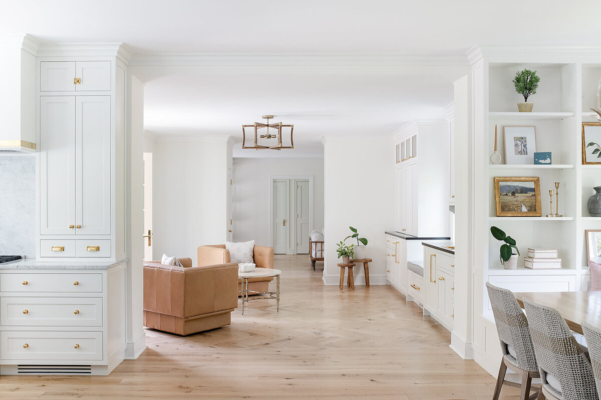 bright white open living space with tan armchairs and light wood floors