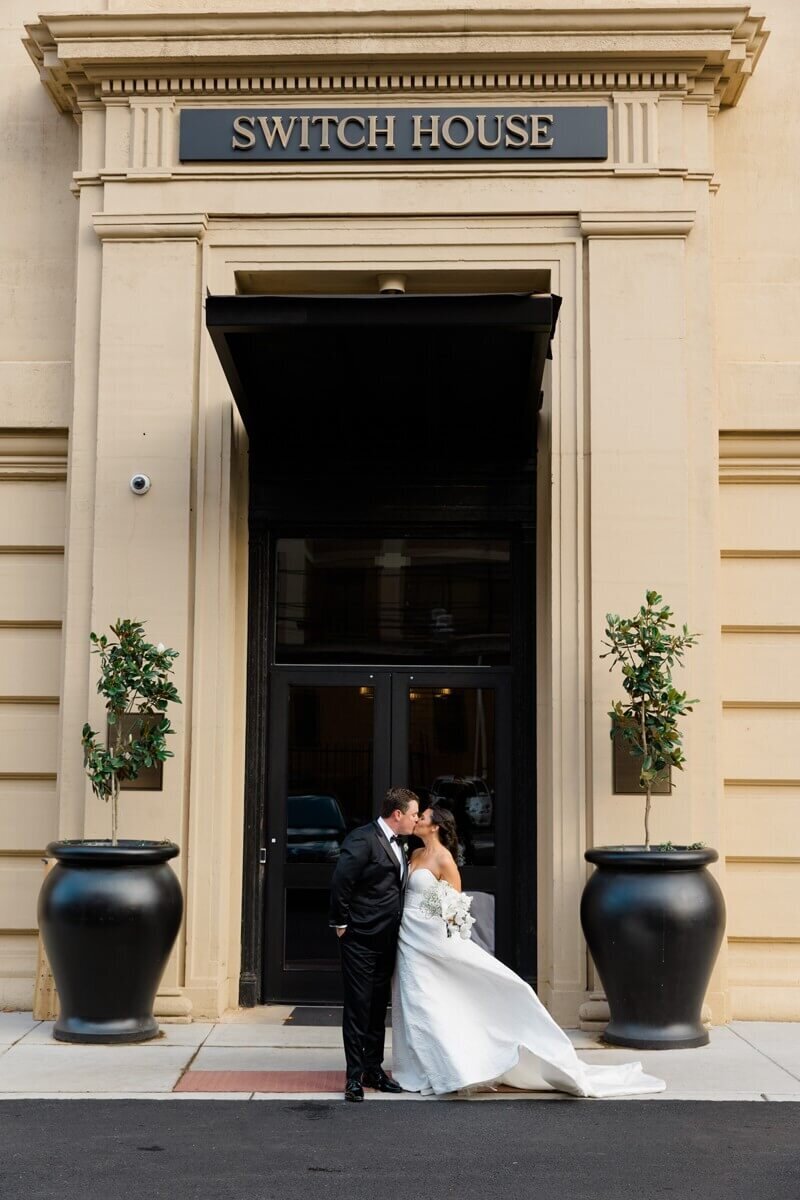 bride and groom standing out front of the switch house