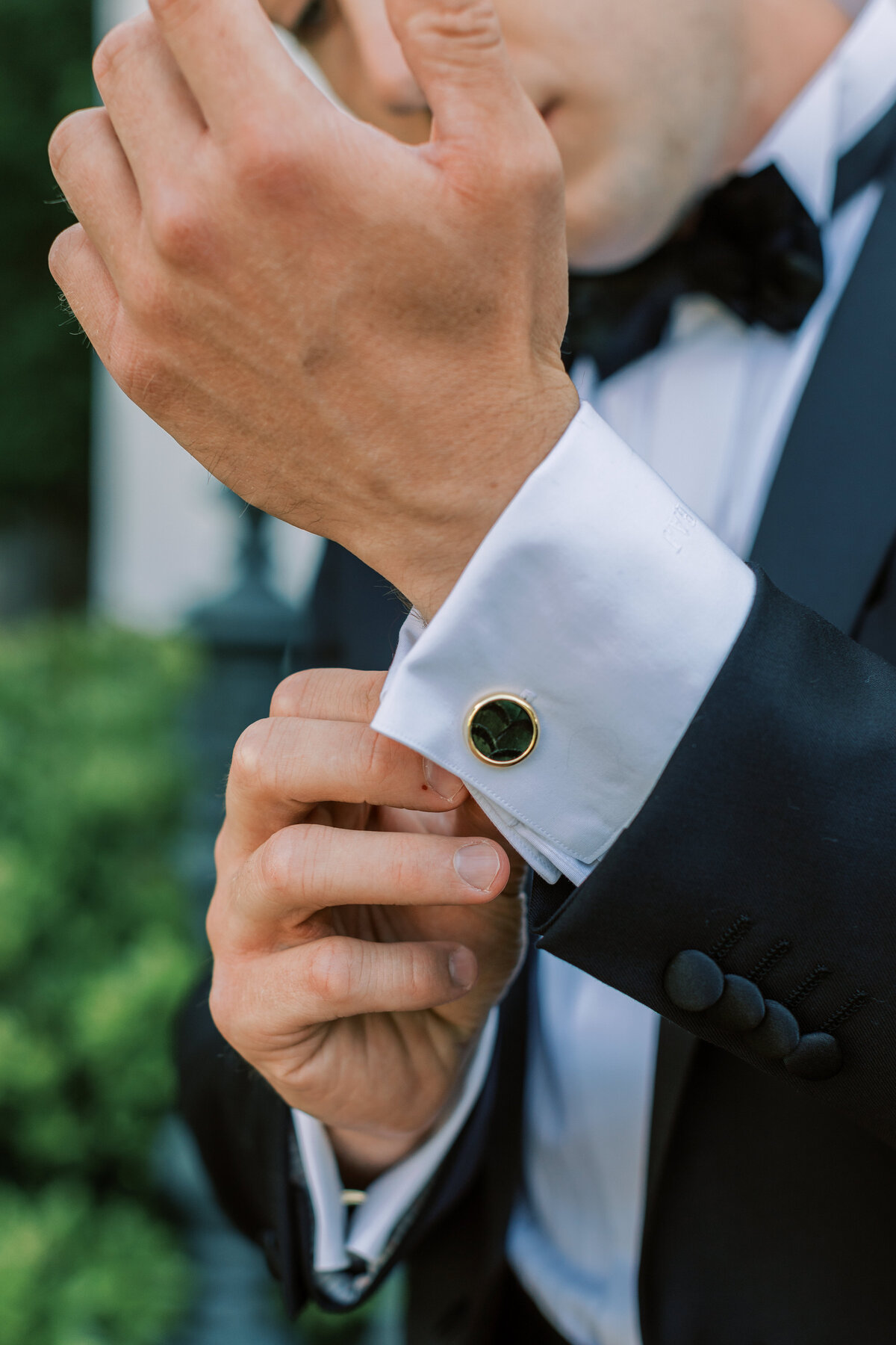 A groom adjusts his cuff link.