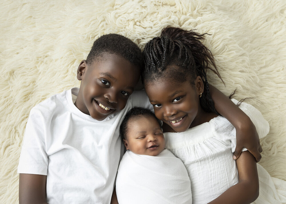 NEWBORN_BABYBOYSMILINGWITHBROTHERANDSISTER