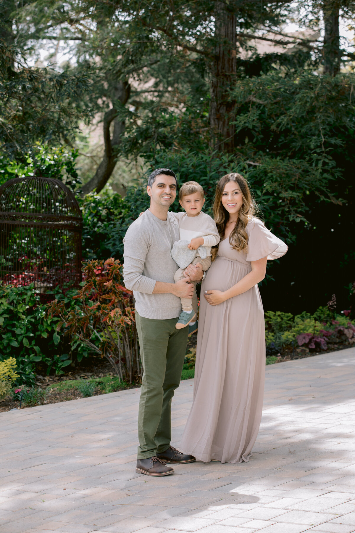 Two parents holding a toddler in between them