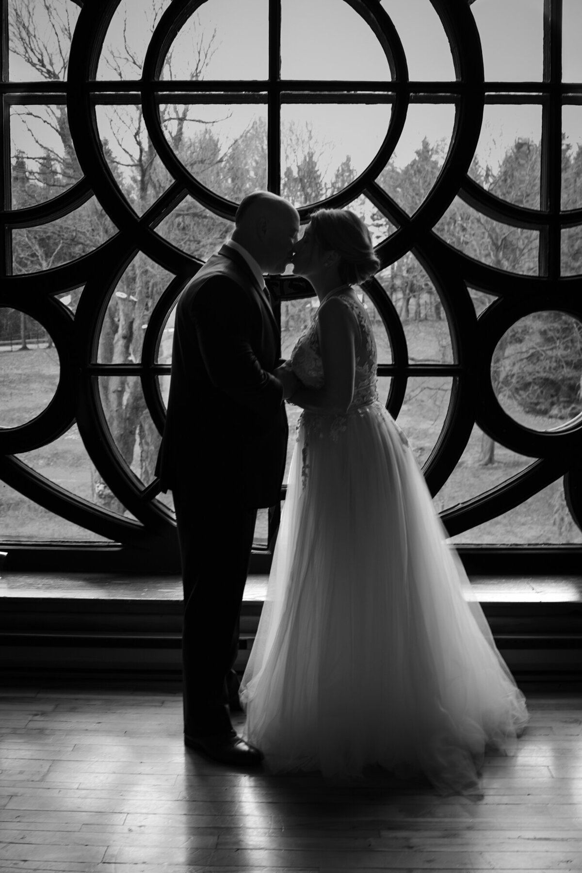 Abbaye d'Oka - Couple de jeunes mariés devant la rosace - Photographe de mariage Montréal