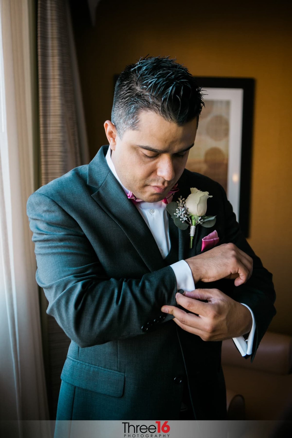 Groom adjusts his cuff link before the ceremony