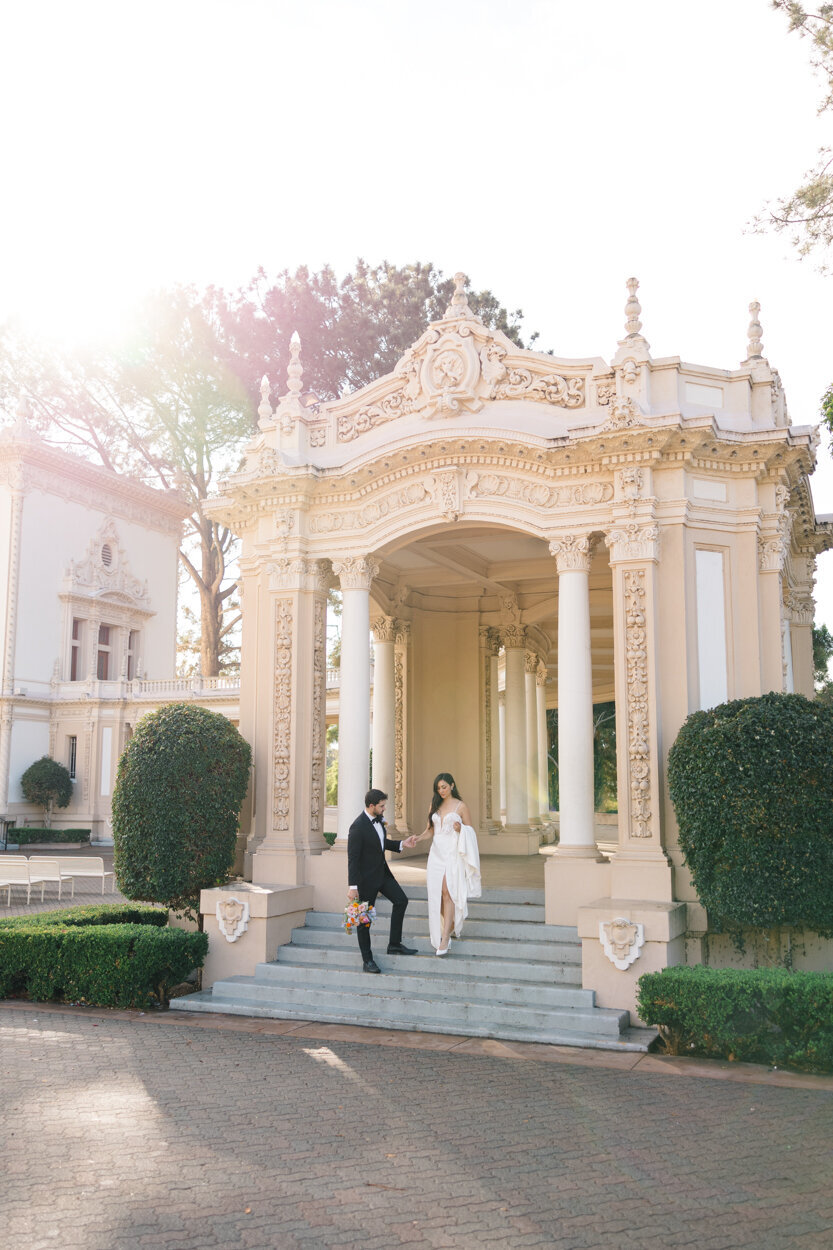 couple walking down the stairs of a grand pavilion