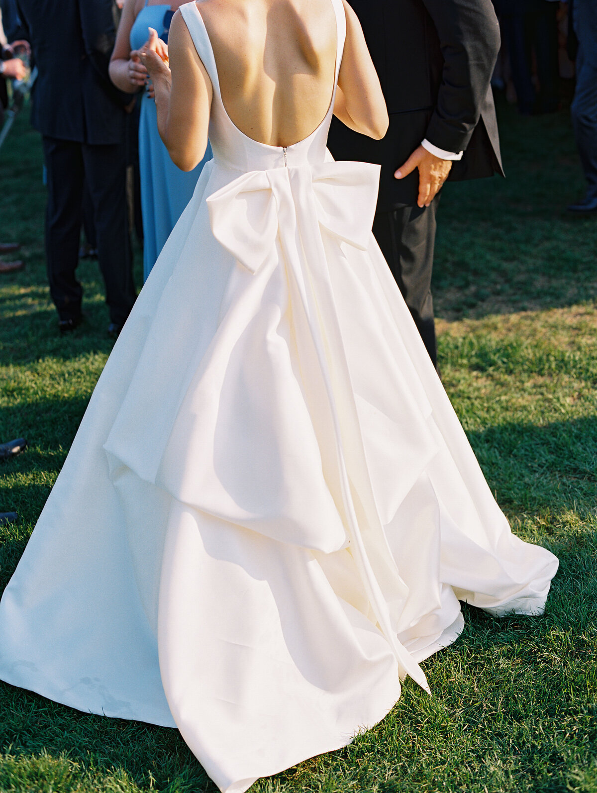 Classic satin wedding gown with scoop back, bateau neckline, and bow detail