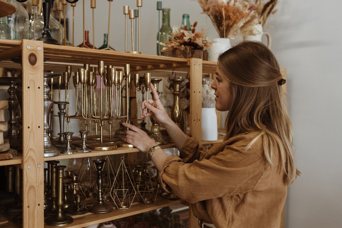 Typhaine du Repère des Pépites range l'un de ses chandeliers disponible à la location