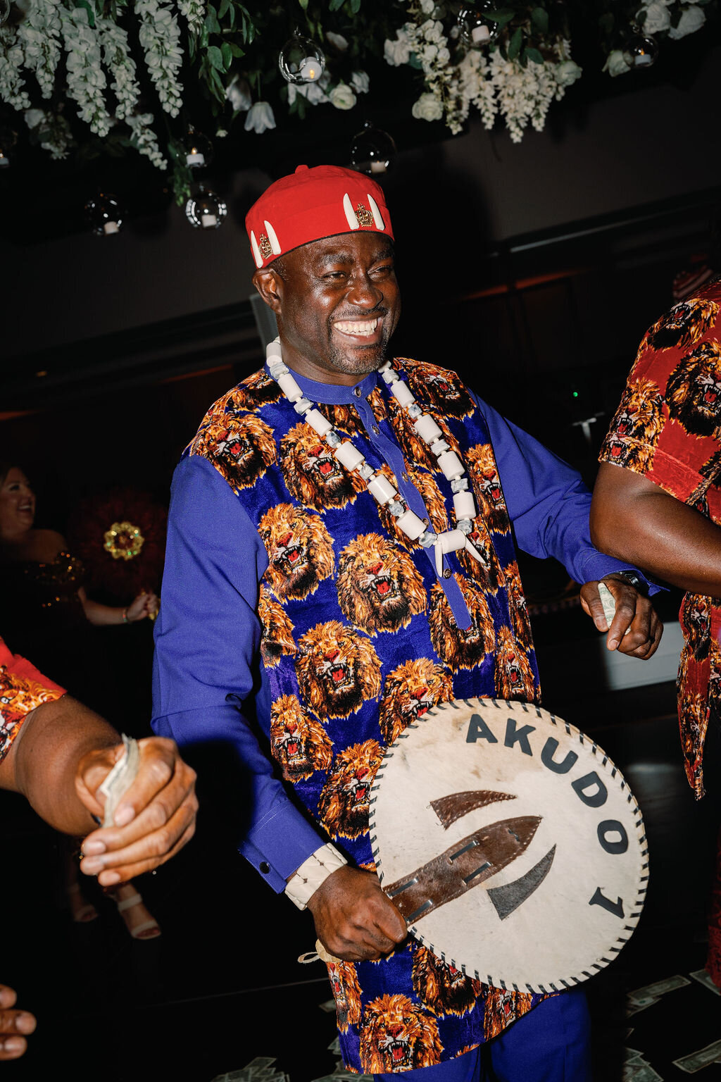 Groom in traditional nigerian attire at wedding reception.