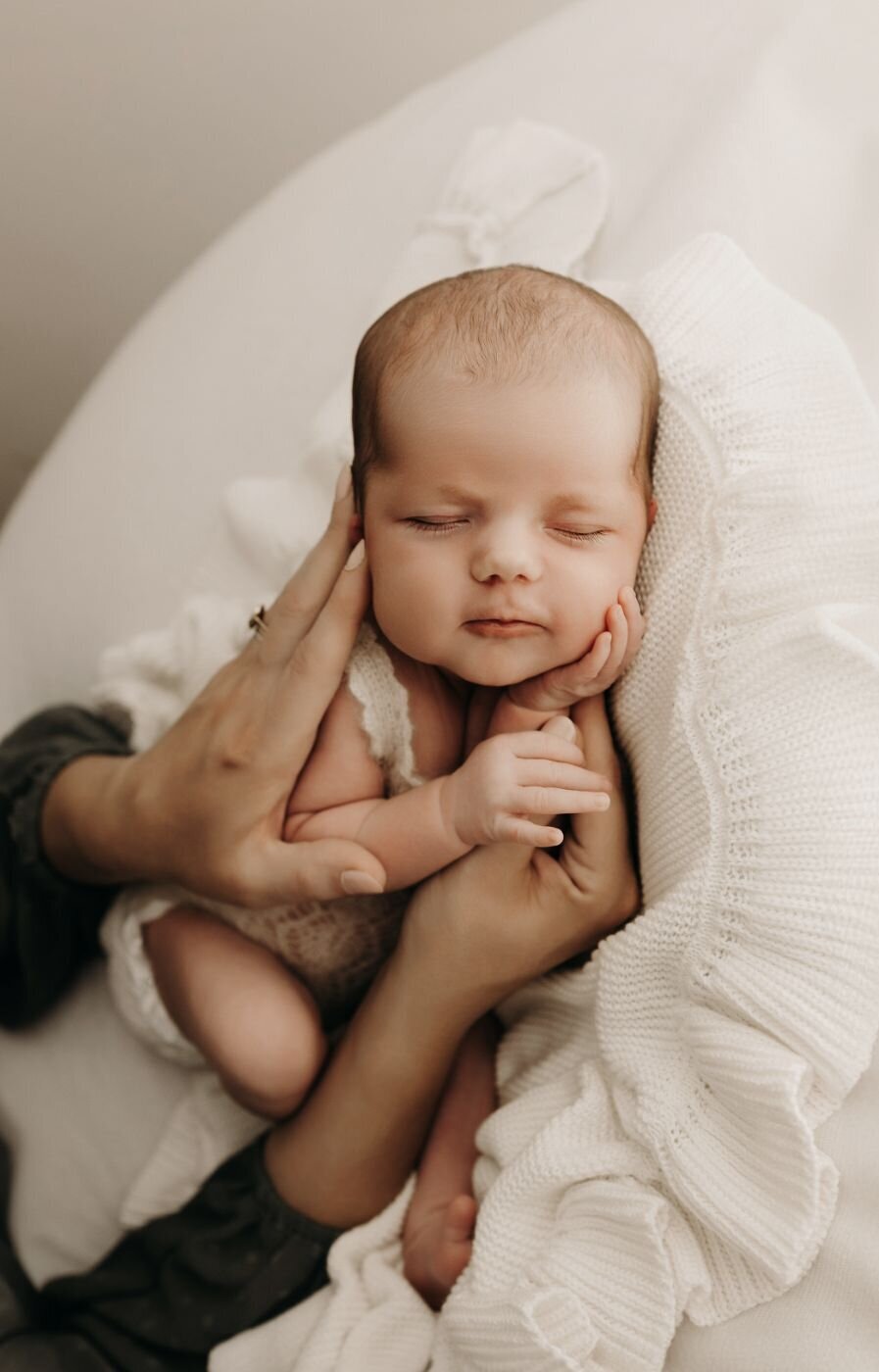 Serene newborn portrait of a baby being lovingly cradled in soft hands in Mullingar, Ireland