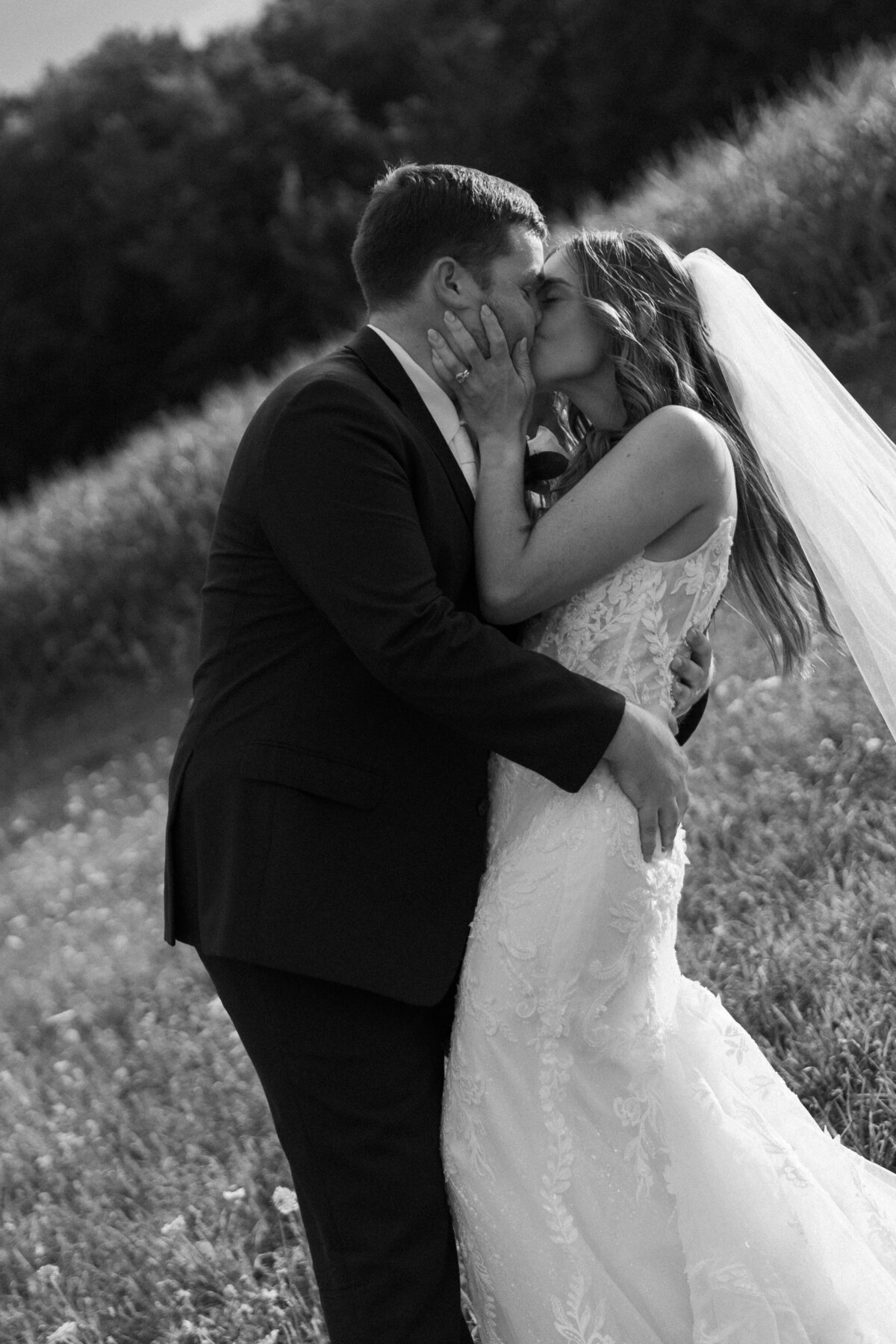 bride-and-groom-black-and-white-kiss-field