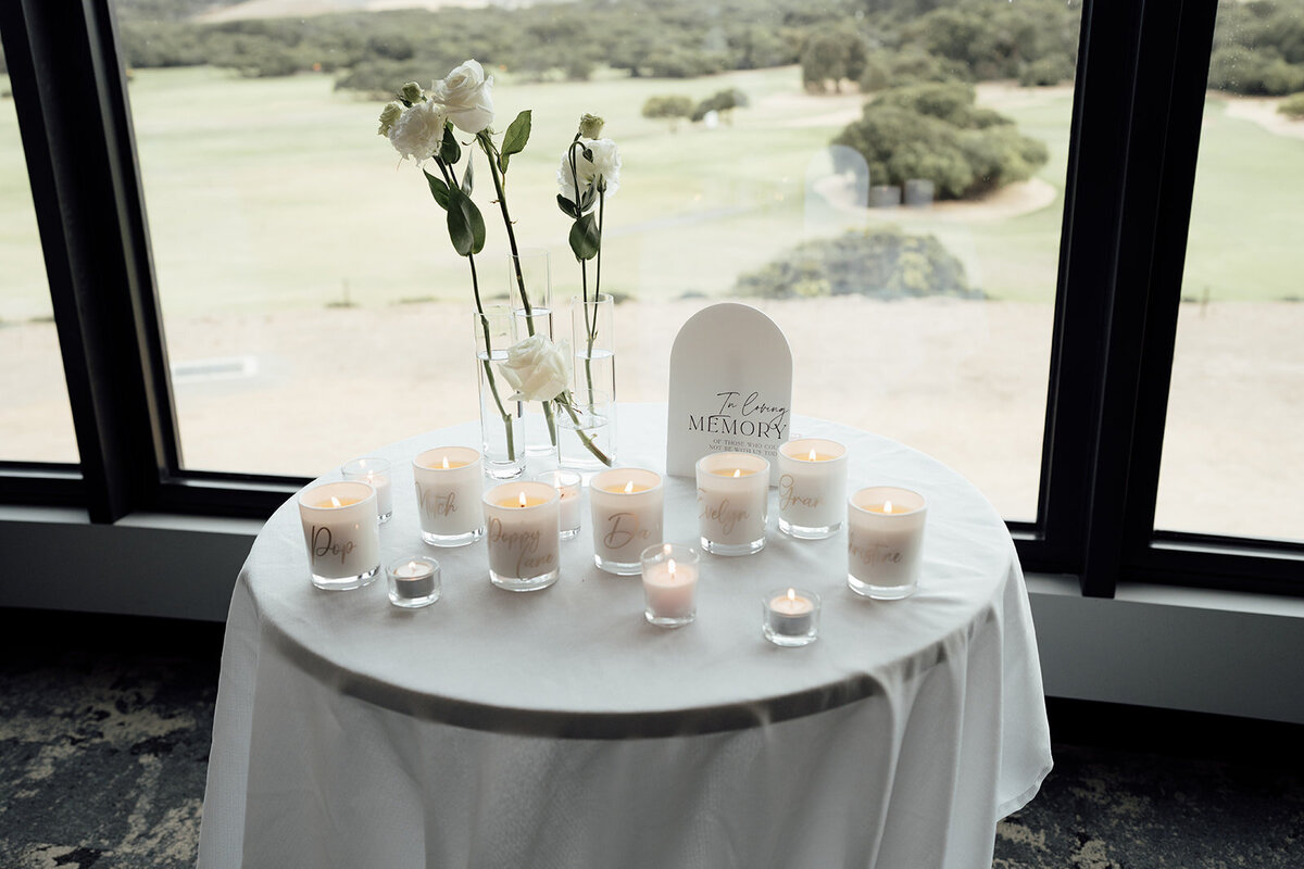 in loving memory table styled with candles and white rose bud vases at the Warrnambool Golf Club