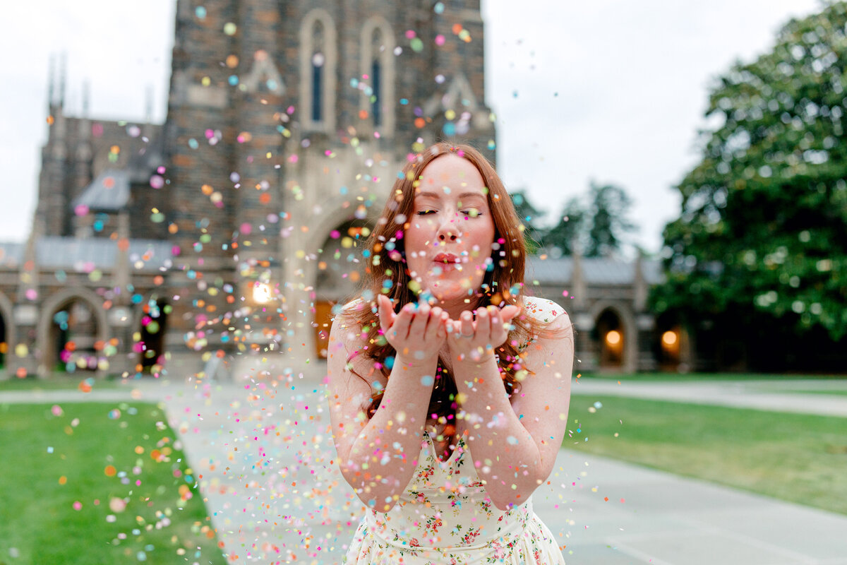College graduate celebrating with confetti during a milestone photo session.