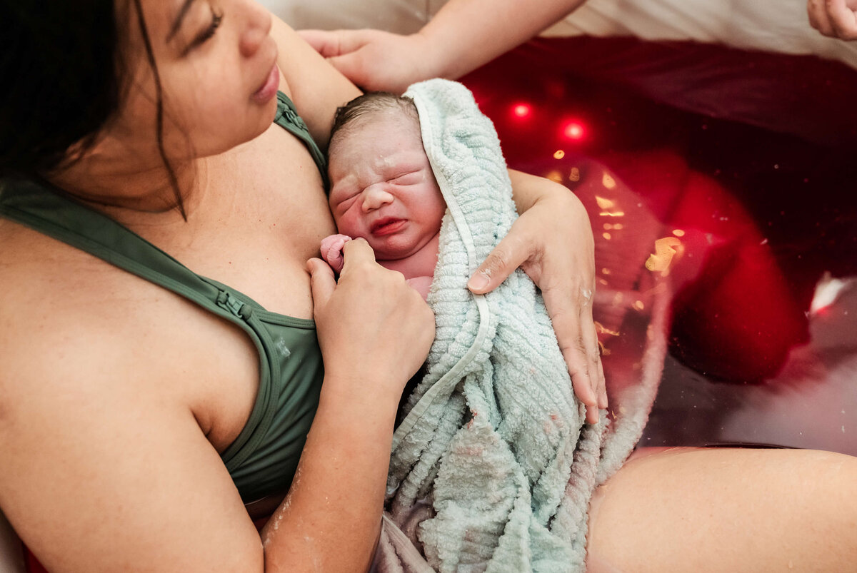 mother-holding-baby-closer-after-water-birth