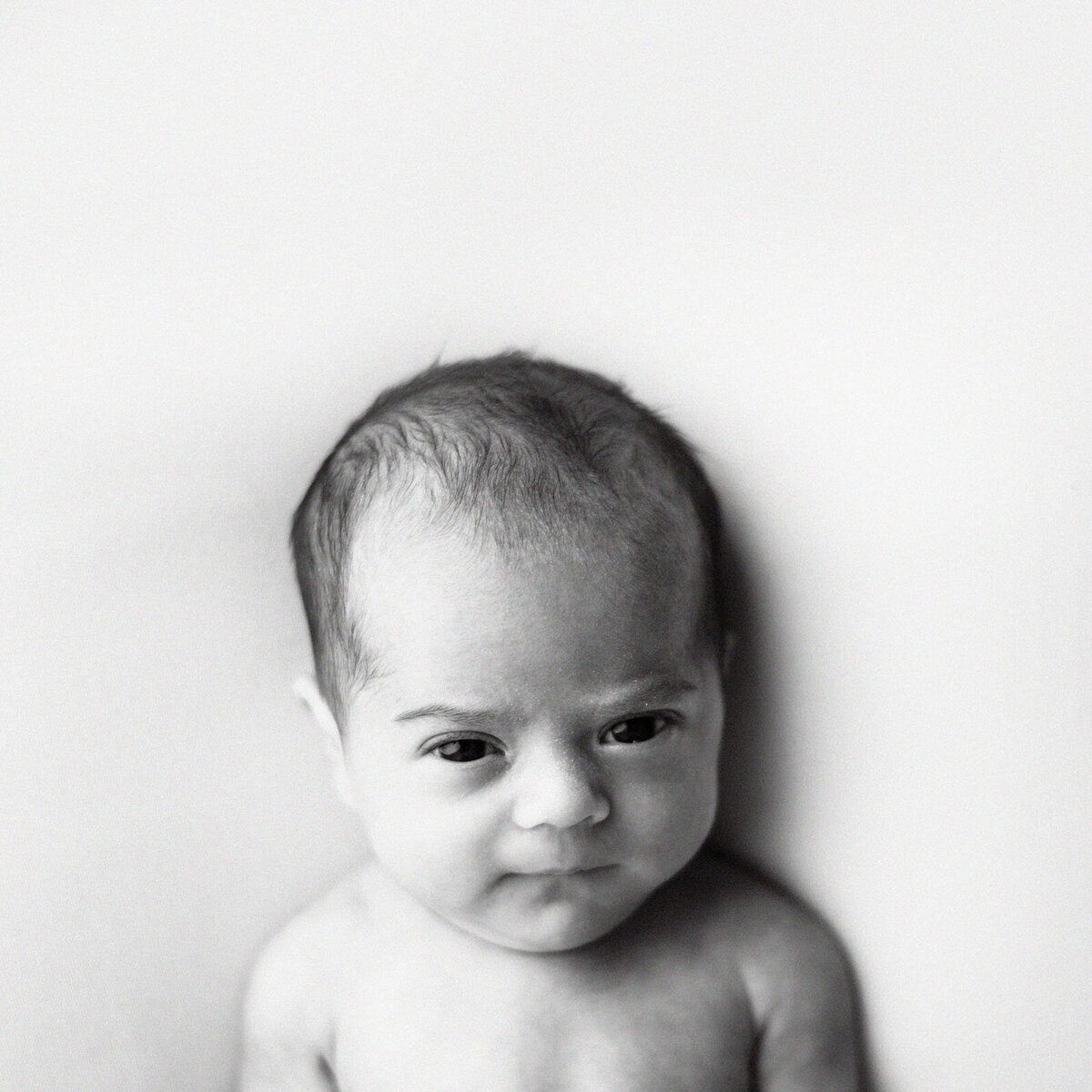 black and white image of baby looking at camera