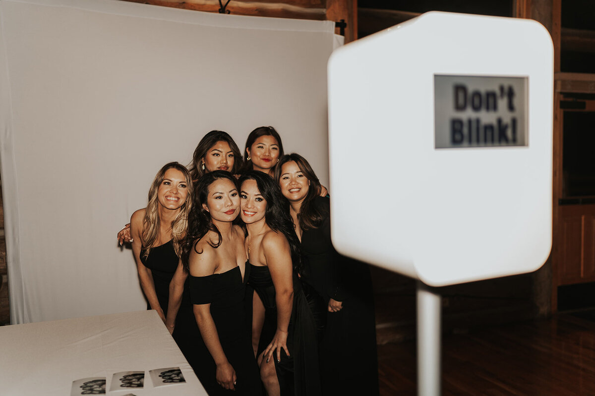 Bridesmaids take a photo at the photo booth for their friend's wedding.