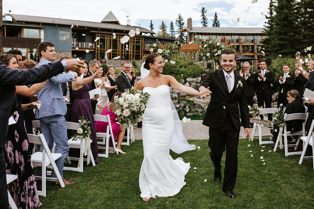 Bride and Groom walking out of their outdoor Azuridge Estate Hotel ceremony, sophisticated and romantic Foothills, Alberta wedding venue, featured on the Brontë Bride Vendor Guide.