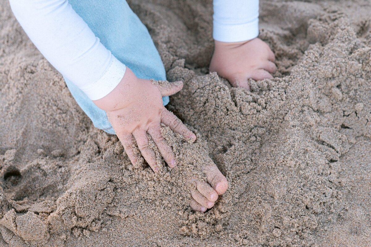 Kinder handjes en teentjes in het zand