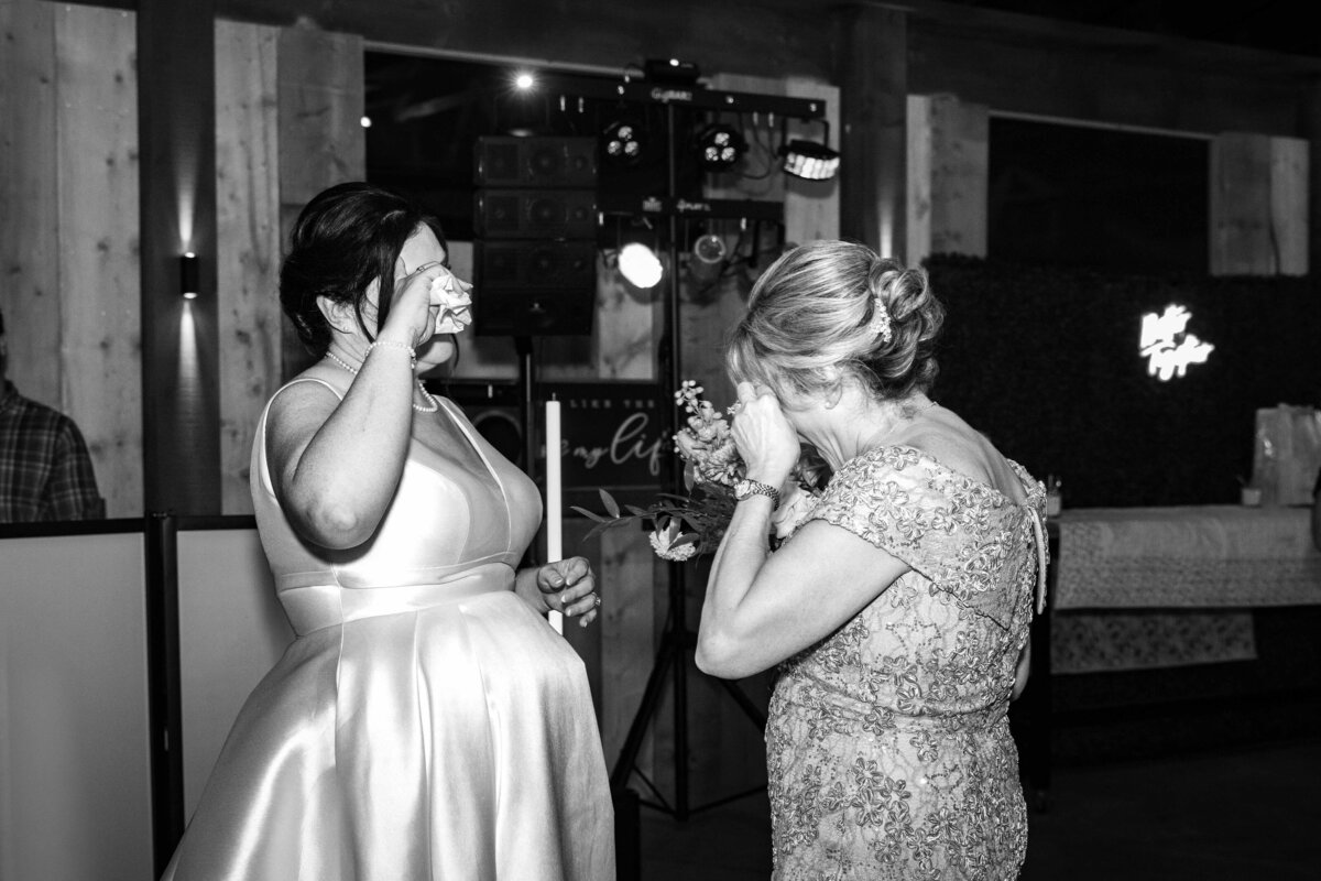 Shannon Lee, from Love Like Wild Photography, captures a bride and a guest wiping tears during an emotional moment at the wedding.