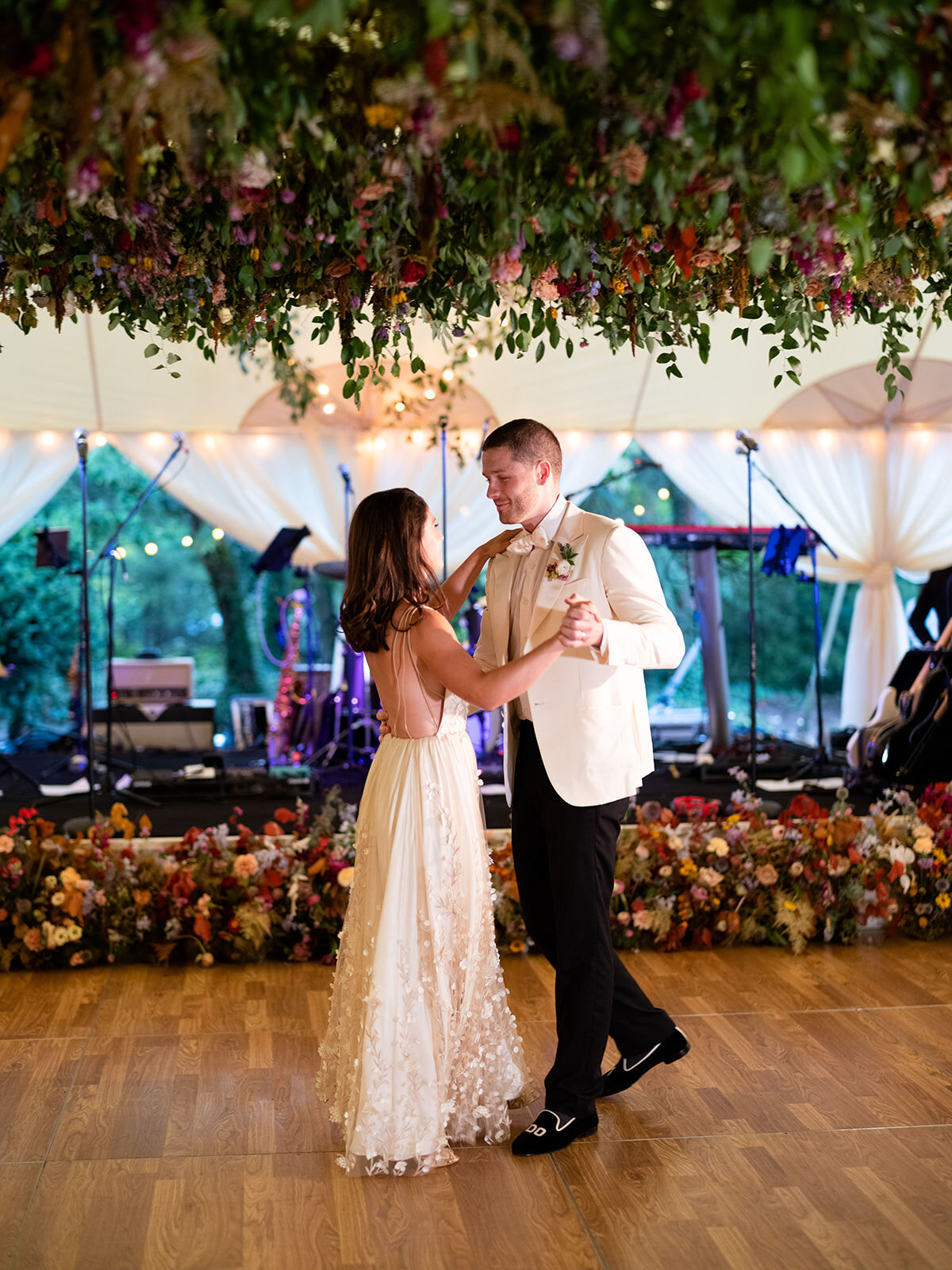 An oversized square hanging flower installation over the dance floor is a great alternative to a floral chandelier! Lush smilax vines, hops, copper beech, and bright wildflowers. RT Lodge and Nashville wedding floral designer.