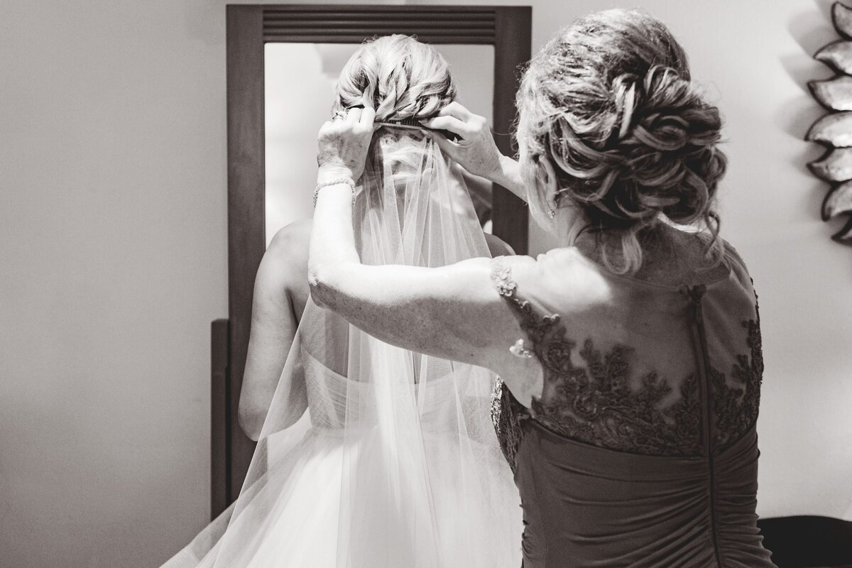 Mom putting on veil at Iberostar Paraiso Riviera Maya wedding