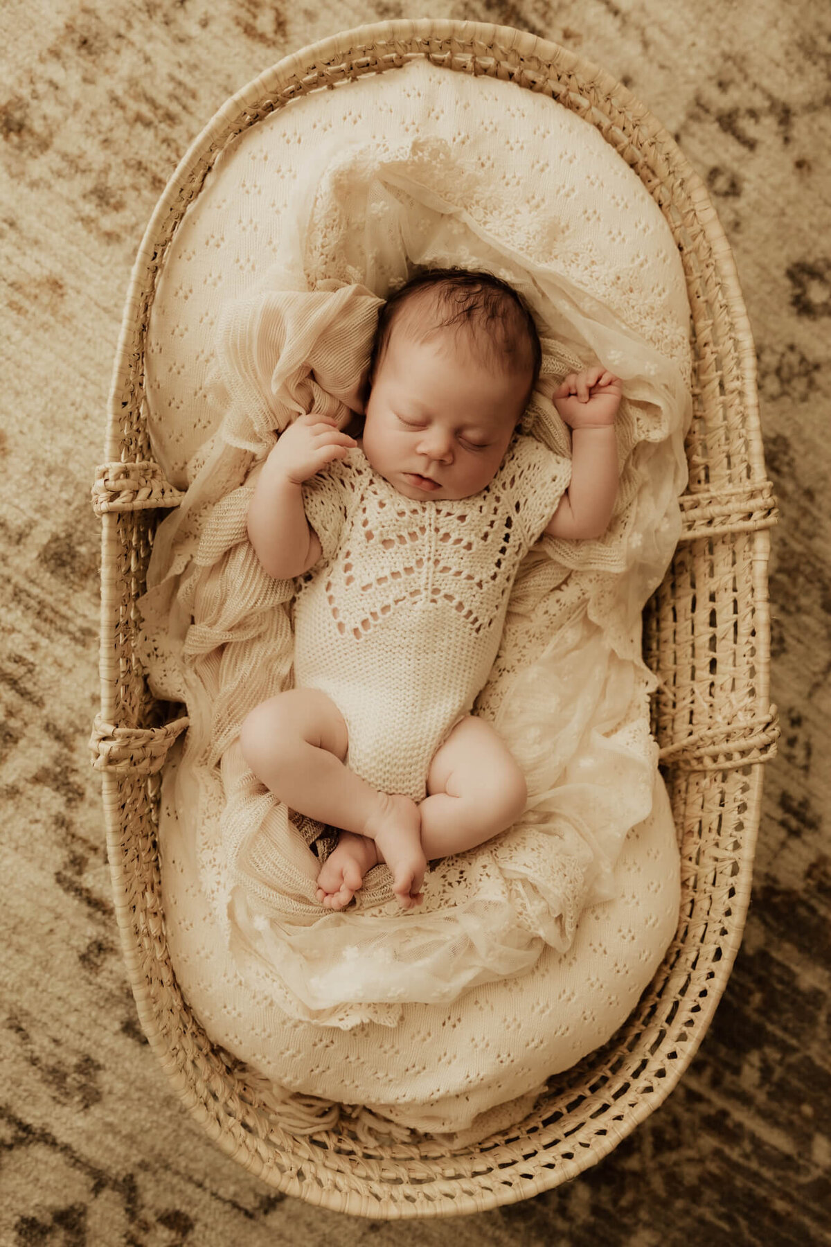 Baby girl in a basket sleeping.