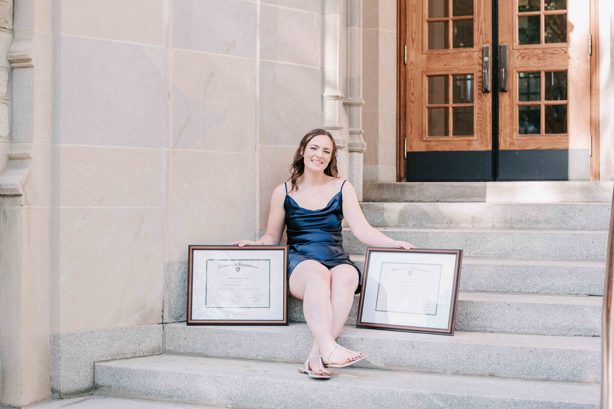 Sitting on concrete steps with her 2 degrees. 