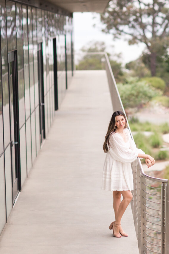 Senior girl leaning against railing at Point Loma Nazarene