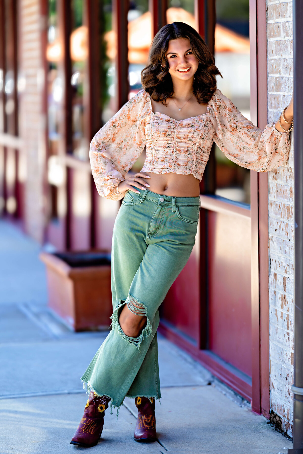 Senior leaning against wall in casual streetwear with soft lighting in Orlando