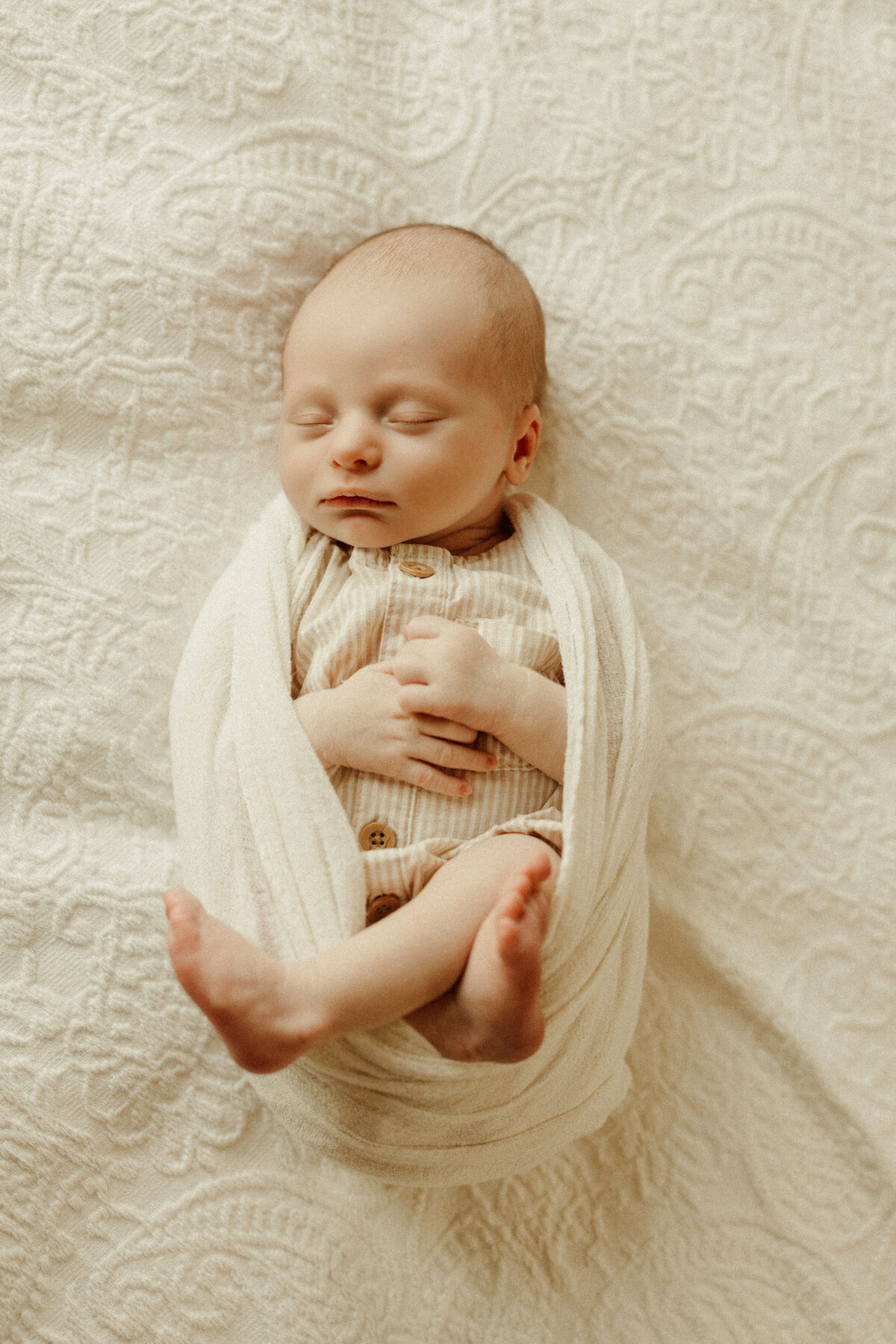 Nostalgic newborn portrait in parents’ bedroom with warm natural light in franklin tn