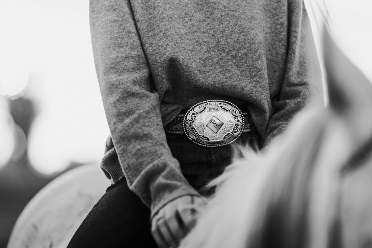 Girl riding her horse bareback with the focus on her belt buckle