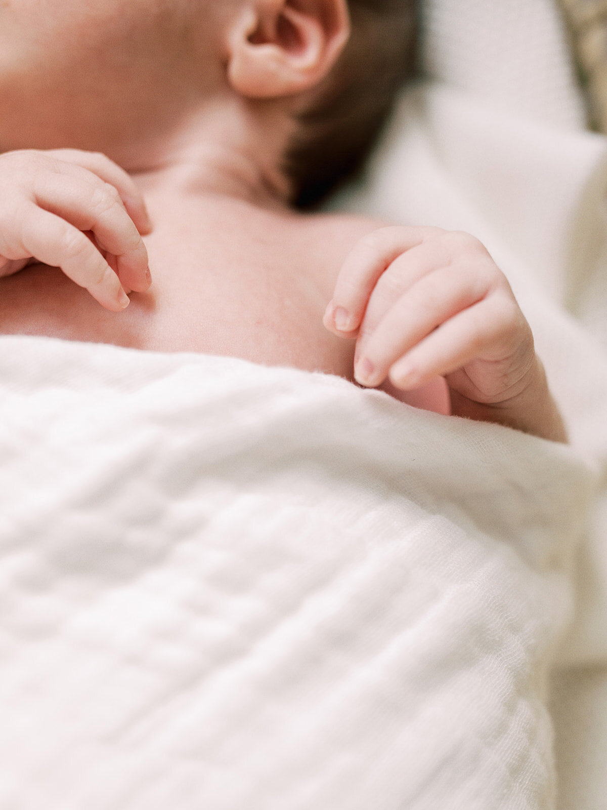 A close-up of a baby's hands while the baby is wrapped in a swaddle during a newborn photography session in Richmond by Katie Stansfield Photography.