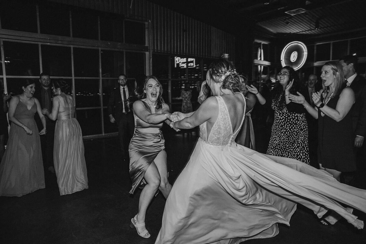 A newlywed dancing with wedding guests 