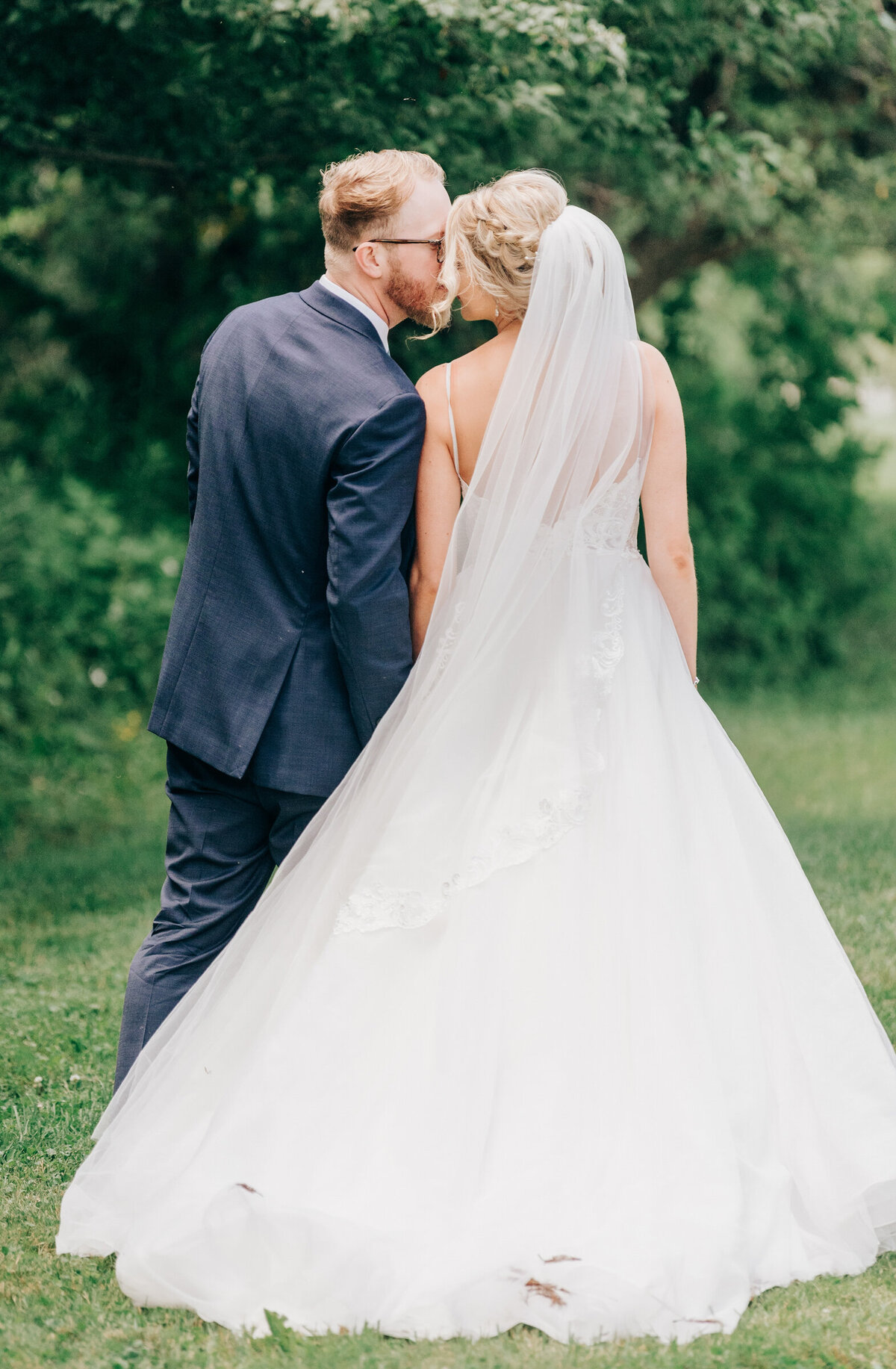 Elegant bride and groom kiss while walking